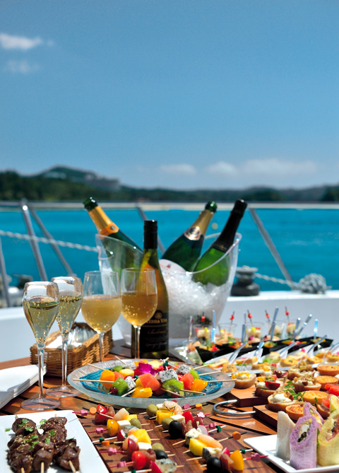 Hors d'oeuvre, champagne and wine bottles on the yacht deck